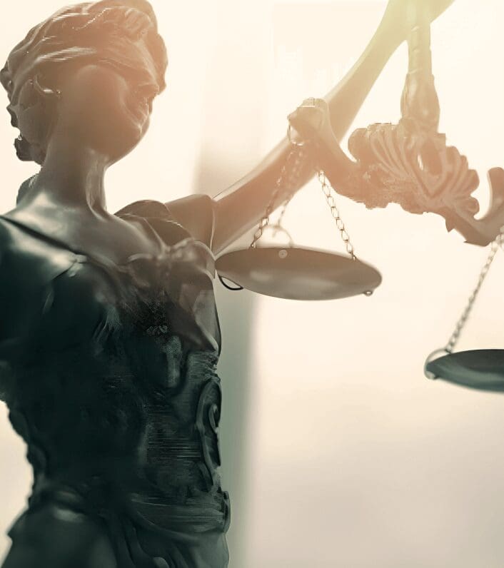 Blindfolded Lady Justice holding scales statue.