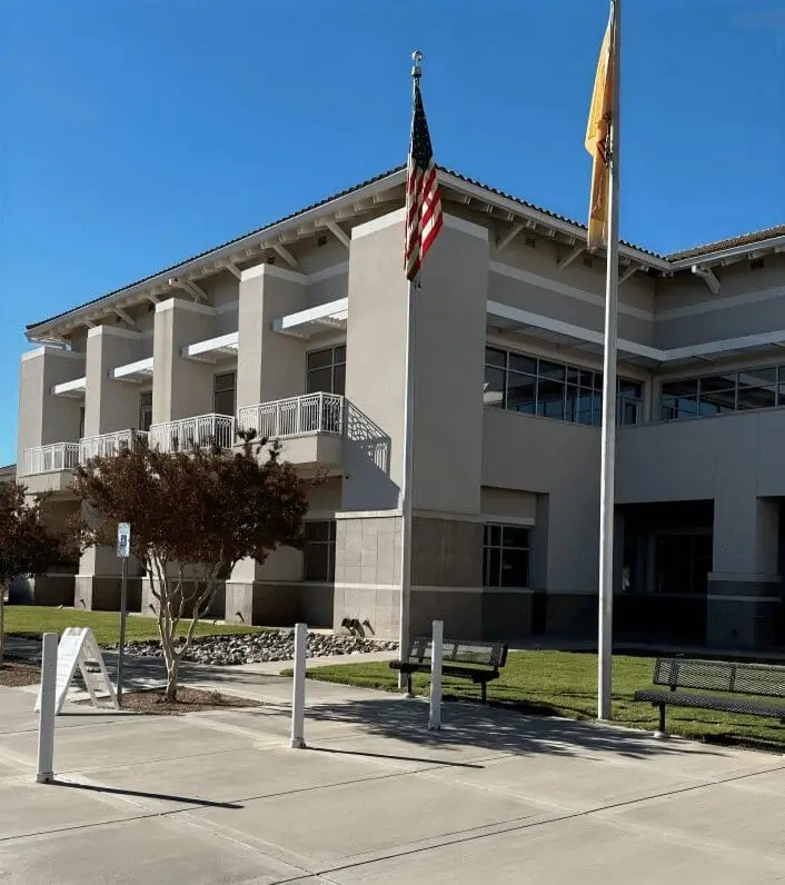 Modern building with flags and clear sky.