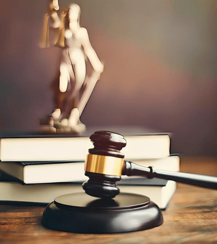 Gavel on sounding block with Lady Justice nearby