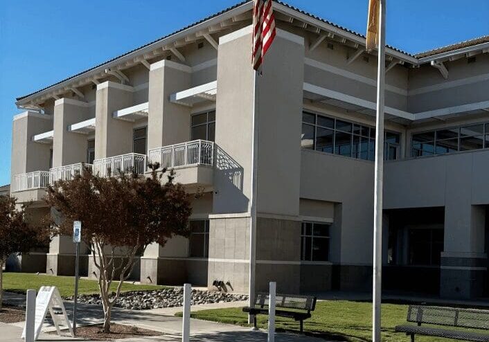 Two flagpoles outside civic center entrance