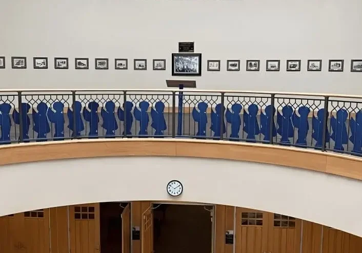 Curved balcony with blue silhouette railing and mural